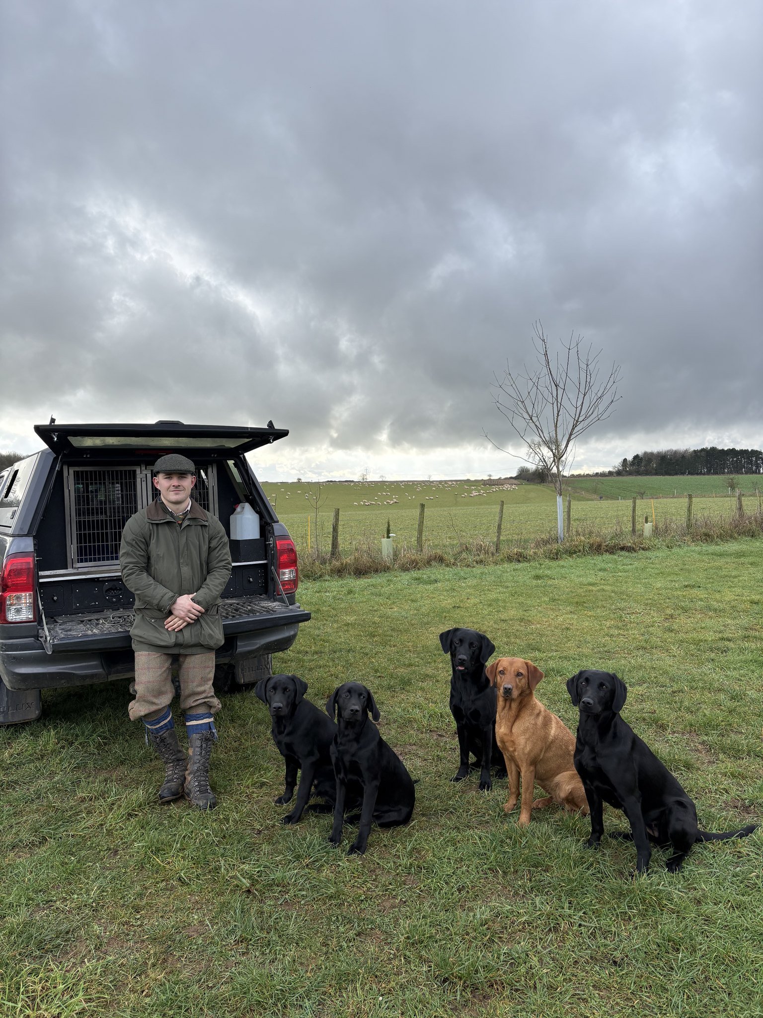 Henry with the whole team lined up beside the truck under a stormy sky